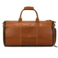 Detail view of the brown leather duffel bag showcasing side zipper pocket and sturdy top handles. - Tan