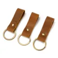 Close-up detail of retro crazy horse leather keychains with bronze metal rings and rivets. - 0066 Style / Random Color