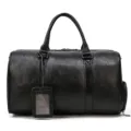 Detail view of the black leather travel duffel bag with handles, luggage tag and side pocket. - 9422-Black