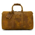 Dettaglio della borsa da viaggio vintage in pelle con manici robusti e pratico etichetta. - Marrone chiaro