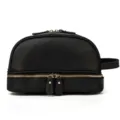 Close-up detail of the black genuine leather double-layer toiletry bag with gold zipper. - Black