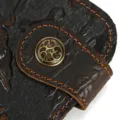 Vue détaillée du portefeuille en cuir de cheval fou marron foncé avec motif gaufré et bouton. - 1010 - boucle à motif gaufrage dragon