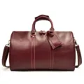 Vue détaillée d'un sac de voyage vintage en cuir véritable bordeaux avec texture de vachette. - Peau Huilée Rouge Vin