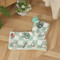 Close-up detail of green and white checkered pet cloak featuring cute fleece animals and pompom. - S / Green Dinosaur