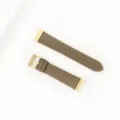 Detail view of a taupe genuine leather watch strap featuring elegant gold hardware and stitching. - Dark Khaki - Gold Buckle