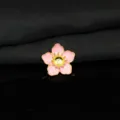 Primo piano di dettaglio dell'accessorio floreale DIY in smalto rosa con nucleo dorato. - Rosa
