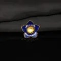 Dettaglio primo piano fiore smalto blu, pistillo dorato accessorio per fai da te creativo. - Blu scuro