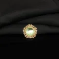 Close-up detail of vintage gold alloy filigree rhinestone round gemstone button DIY craft accessory - Light Green