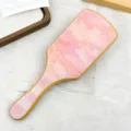 Detailed view of a premium pink marble acetate hairbrush featuring a natural bamboo handle - Pink