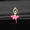 Close-up detail of the gold alloy crystal ballet dancer pendant with pink crystal skirt and rhinestones. - Rose Red