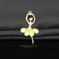 Close-up of a gold alloy ballet dancer pendant with sparkling rhinestones and green crystal. - Light Green