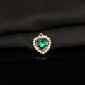 Close-up view of the green heart rhinestone pendant detail, shimmering crystal and alloy texture. - Dark Green