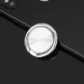Close-up of silver metal phone ring holder with CD texture, mounted on black smartphone back. - Silver CD Pattern