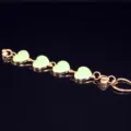 Close-up detail of gold alloy chain with light green oil-drop heart charms for DIY phone case decor. - Green Heart
