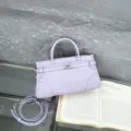 Detailed view of the lavender leather Kelly handbag featuring top handle and metal lock. - Yves Saint Laurent