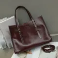Vista detallada del bolso de mano vintage de cuero marrón con correas de hebilla metálica. - Café Vino