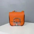 Detail view of the orange leather shoulder bag, showing premium grain cowhide and silver hardware. - 19 / Orange