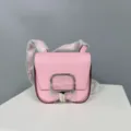 Pink leather saddle bag detail shot, compact crossbody shoulder bag with metal lock. - 19 / 3Q Pink