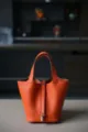 Oranje lederen emmertas shopper tote tas met hangslot hardware, klassieke minimalistische stijl. - L18 B13 H18 cm / Hermès oranje met zilveren gesp