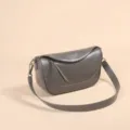 Primer plano del bolso de hombro de cuero gris oscuro con costuras finas y correa ancha. - Gris Premium