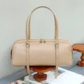 Leather shoulder baguette bag detailed view, minimalist cylinder design with adjustable strap. - 34*12*13 cm / Apricot