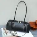 Detail view of the black leather baguette shoulder bag, showing fine hardware and texture. - 34*12*13 cm / Black