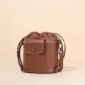 Elegant brown leather bucket bag for women, chic crossbody shoulder bag with secure drawstring. - Brown