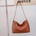 Borsa a spalla in pelle marrone da donna, design hobo morbido con accessorio catena. - Colore caramello