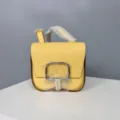 Yellow leather mini saddle crossbody bag detail view showing fine grain texture and metallic clasp. - 19 / Light Yellow