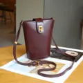 Burgundy genuine leather mini bucket shoulder bag detail with fine metal lock and adjustable strap. - Wine Coffee