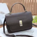 Elegant brown leather top-handle crossbody bag with structured design and secure metal clasp. - Chocolate