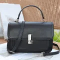 Classic black genuine leather shoulder bag with top handle and stylish metal lock closure. - Black