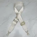 Detail view of the adjustable beige woven crossbody bag replacement strap with gold hardware. - Off White