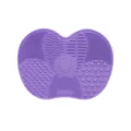 Purple silicone makeup brush cleaning mat with textured scrubbing areas and suction cups - Purple
