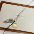 Long sweater chain necklace featuring a metal handbag pendant and beaded tassel details. - Gold Bag Necklace Style (Z-4530)