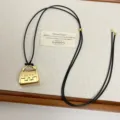 Detailed view of the gold mini handbag pendant necklace with black cord and delicate display. - Gold Bag Style (Z-4526)