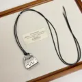 Detailed shot of a stylish silver metal handbag pendant necklace with black cord. Perfect charm. - Silver Bag Style (Z-4527)