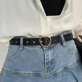 Black leather belt with heart buckle and cutouts worn with denim skirt for women fashion daily - Black