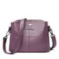 Borsa a tracolla in pelle viola da donna, elegante borsa a spalla con logo in metallo e tracolla. - Viola