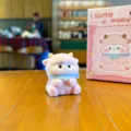 Flocked cute little lamb plush toy desktop ornament with blue scarf and pink gift box. - Color Box / Lamb