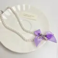 Detailed shot of sweet double-layer pearl necklace featuring purple ribbon bow and alloy charm. - Necklace