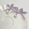 Detailed close-up of elegant sweet double ribbon bow pearl drop earrings in silver tone. - Earrings