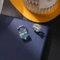 Exquisite silberfarbene Ohrkappen mit hellblauem Herz-Kristall und funkelnden Pave-Steinen. - Clip-Ohrringe