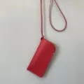 Detailopname van een stijlvolle rode lederen brillentas opbergtas met nekband. - Rode Stijl (Z-2812)