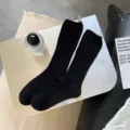 Solid black mid-calf socks for women, featuring a mesh texture and comfortable cotton fabric. - One Size / Black