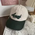 Detailed close-up of two-tone baseball cap with green brim and contrast embroidery design. - 55-59 / Beige and Dark Green
