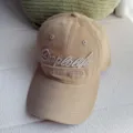 Vista detallada de la gorra de béisbol de pana lavada vintage con elegante bordado frontal. - Caqui