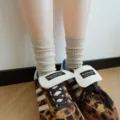 Detail shot of cozy beige ribbed crew socks worn with trendy leopard print sneakers. - One Size / Plain Knit - Oatmeal