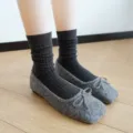Close-up detail view of dark grey ribbed knit mid-calf crew socks paired with stylish flat shoes. - One Size / Plain Knit - Dark Gray
