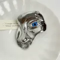 Close-up detail of the creative metal eye brooch with glossy finish and blue eyeball inlay. - Silver Z-1103